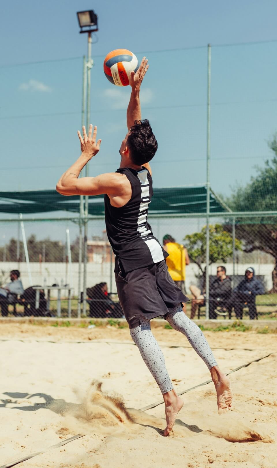 Volleyball player spiking at the net