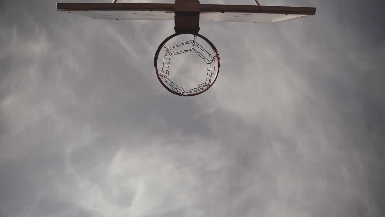 Basketball hoop above an outdoor court at dusk